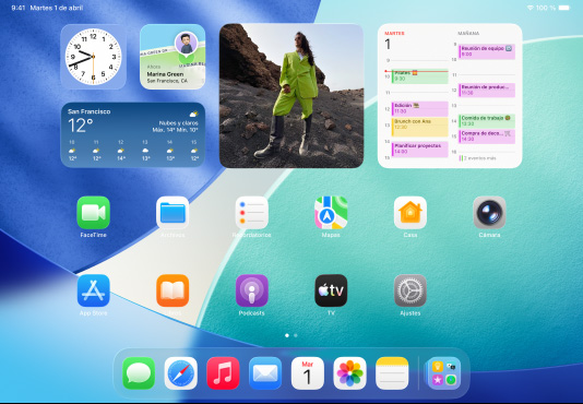 Tres modelos de iPad en posición horizontal. El modelo central se encuentra delante de los otros dos y lleva un Apple Pencil acoplado magnéticamente. Muestra la pantalla de inicio con varios iconos de apps de colores con efecto Liquid Glass. La pantalla de la izquierda muestra la app Vista Previa. Y la de la derecha muestra la pantalla de inicio con archivos que se despliegan desde el Dock.