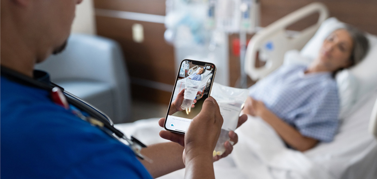 Un infirmier contrôle le traitement d’une patiente avec iPhone.